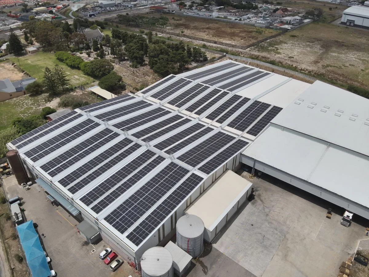 Rooftop solar array on a Philippi manufacturing facility with process storage tanks alongside